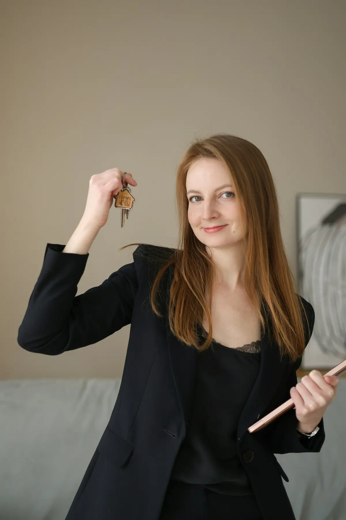 Real-estate professional holding house keys and a clipboard