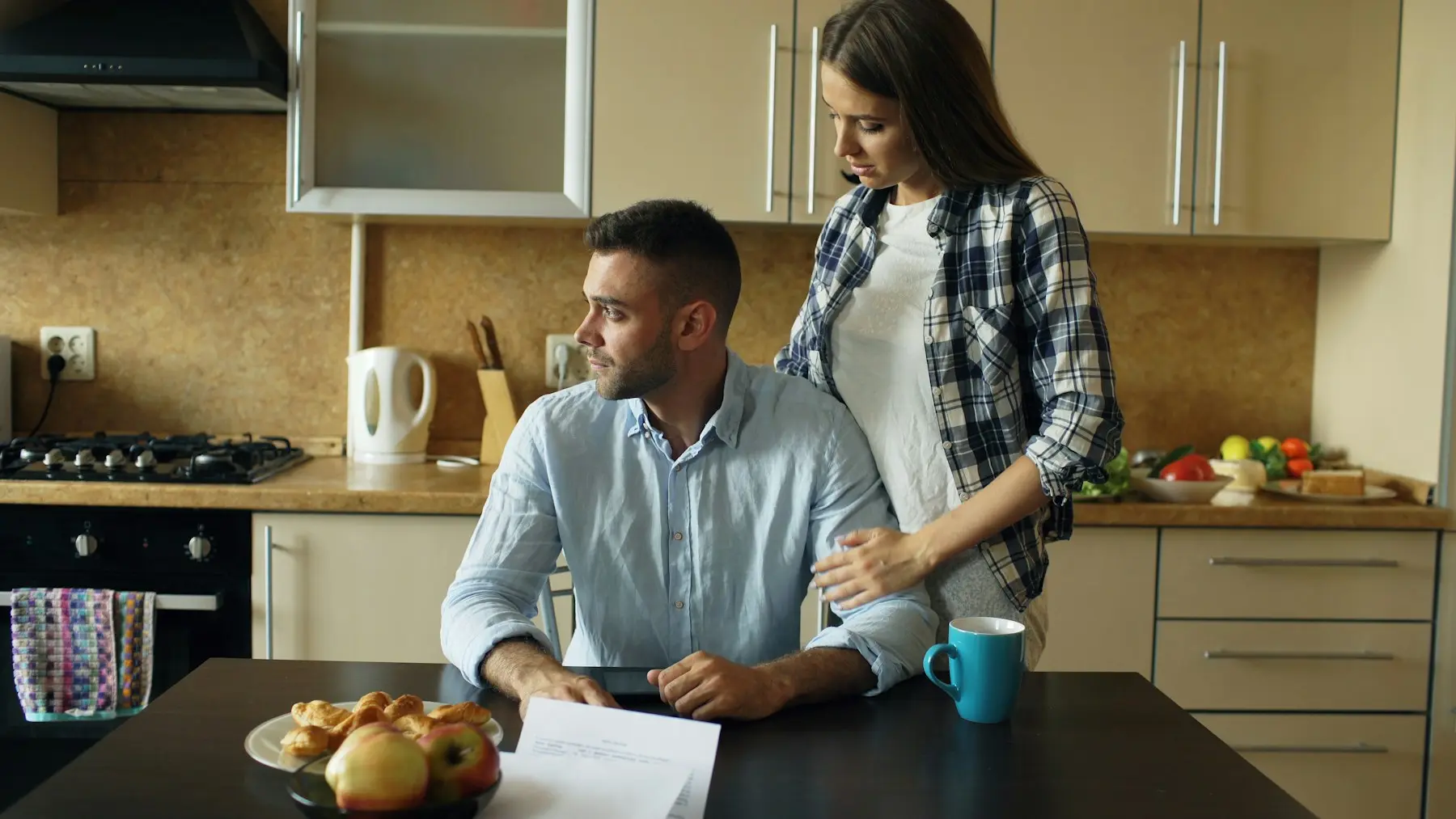 Couple reviewing household bills together at their kitchen table