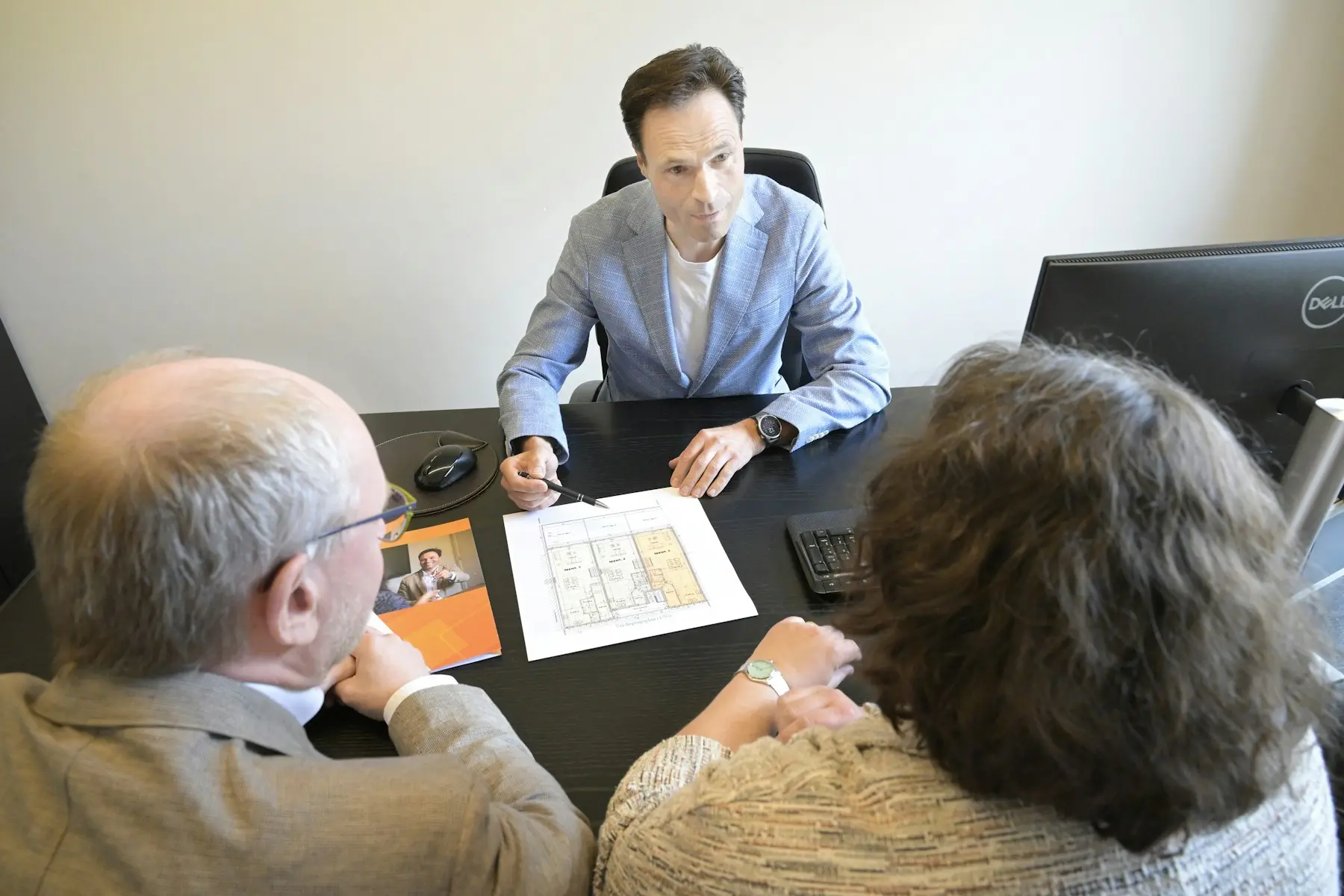 Housing adviser explaining building plans during a client meeting